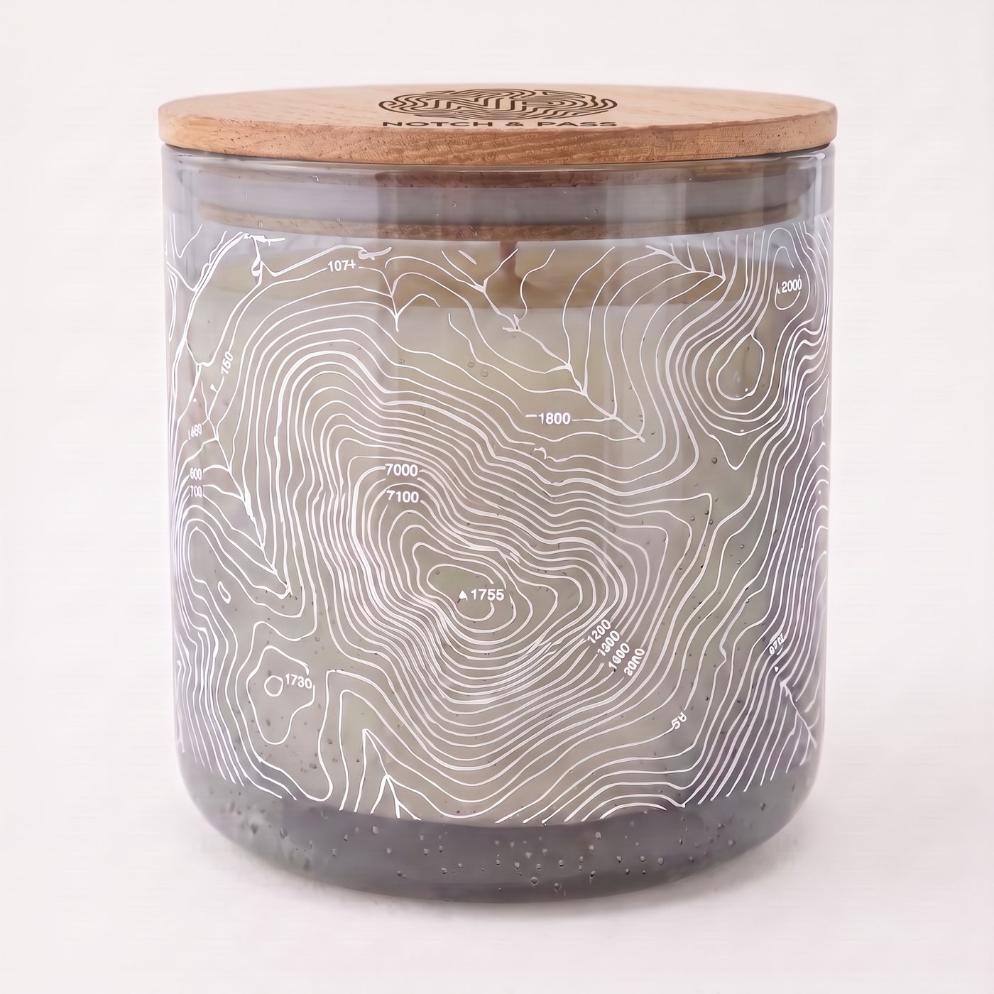 The Fir & Balsam candle: grey bubble glass, white contour print, pine lid with the mark burnt in