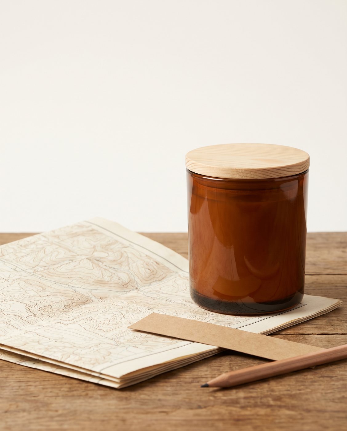 A folded USGS sheet, a blank label strip, a pencil and a plain amber jar on a wooden table